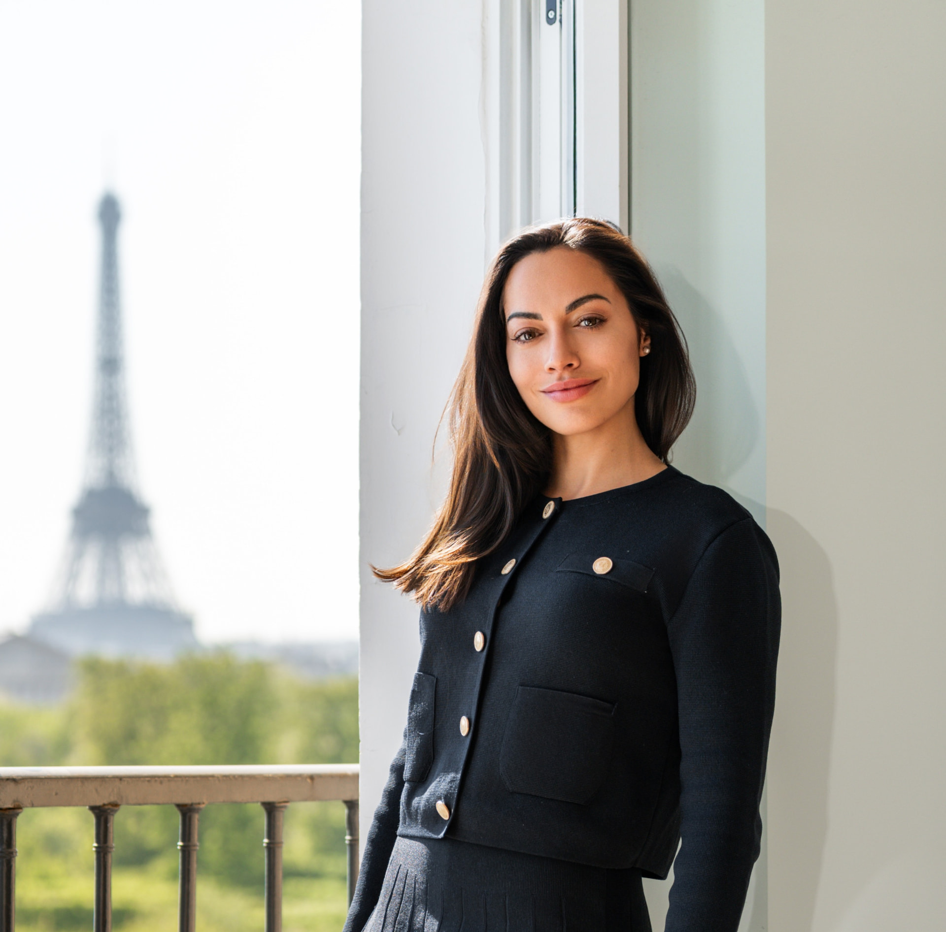 Portrait de la fondatrice de Rente Consulting devant une fenêtre parisienne avec vue sur la tour Eiffel